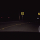 A dark road with signs warning of a sharp curve. (Screenshot: Twin Peaks)